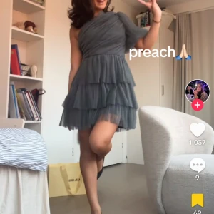 Grå oneshoulder klänning med volanger - Nypris 3500. Helt ny med prislappen kvar är storlek  m men sitter som s  ( första bilden lånad) 