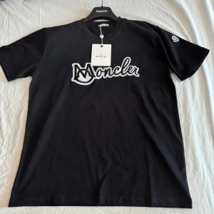 Moncler T-shirt  (helt ny) - Jag fick den i present och den är lite för stor, min bror bor i USA och därför kan jag inte direkt lämna tillbaka den bara så. Jag vet inte heller om priset är så rimligt men det kan vi diskutera privat. Den är helt oanvänd , etikett och original paketering ingår också. Hör av er vid minsta lilla fundering och ni får lova att inte berätta att jag säljer den för min bror 😂🥴