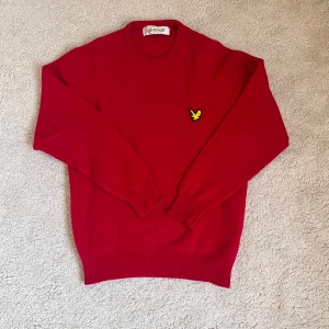 Röd lammullströja från Lyle & Scott - Säljer en klassisk röd tröja från Lyle & Scott i 100% lammull. Tröjan har en broderad gul logotyp på bröstet och ribbade muddar vid ärmslut och nederkant. Perfekt för kyligare dagar! Väldigt sällsynt och "rare" från 90 Talet Sitter som stlk M. Dma för frågor eller att sänka pris ❤️