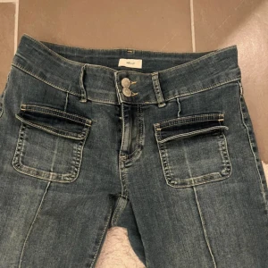 Blå jeans med fickdetaljer - Trendiga jeans från Nelly i strl S🩵 Lågmidjade och bootcut! Skriv för frågor eller fler bilder🥰Passar mig som är 174cm! Ser oanvända ut, innerbenslängden är 83-84cm och midjemåttet rakt över är 36cm💓