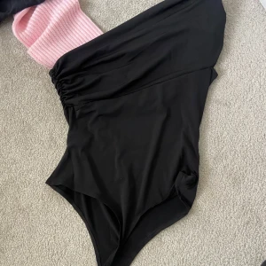 Svart baddräkt från H&M - Snygg svart body från H&M med en stilren design. Perfekt för utgång som dagligen. Den har en enkel och elegant look som passar alla tillfällen.