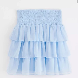 Ljusblå  kort volangkjol - Helt ny med prislapp kvar. Storlek 170.  Elastiskt strechigt band vid midjan så kan passa xs, s och m. 