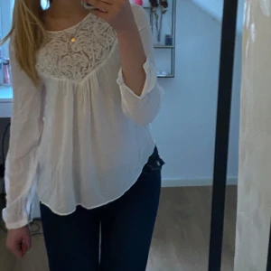 Vit spetsblus från zara - Säljer en söt vit blus med långa ärmar och vackra spetsdetaljer upptill. Blusen har en lös passform och är tillverkad i ett lätt, luftigt material som är perfekt för varma sommmar och vårdagar. Perfekt att styla med jeans eller kjol. Har används enstaka gånger. Hör av dig vid frågor eller interesse💞