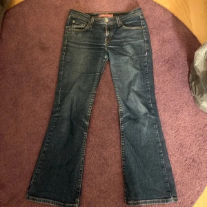 Levis 527 bootcut jeans - Mörkblå Levis 527 jeans med bootcut passform och låg midja. Snygga kontrastsömmar och Levis-logga på bakfickan. Perfekta för dig som gillar en tidlös jeansstil med lite utsvängda ben.