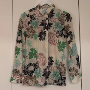Blommig skjorta från Carin Wester - Skjorta från Carin Wester med  blommönster. Skjortan har klassisk krage, knäppning framtill och långa ärmar. 