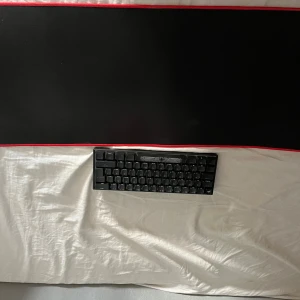 Svart mekaniskt tangentbord med mus matta bilden är uppochner - Säljer ett kompakt svart mekaniskt tangentbord med låg profil. Tangentbordet har en minimalistisk design och passar perfekt för gaming eller arbete vid datorn.