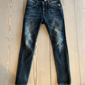 Mörkblå Replay Jeans - Snygga mörkblå jeans från Replay med knappar framtill. Storlek 24, model Pilar. Super snygg tvätt, lös model upptill och smalare vid bena. 