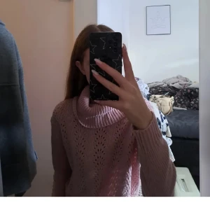 Rosa stickad polotröja - Säljer en mysig rosa stickad polotröja med ett fint hålmönster. Tröjan har långa ärmar och en bred polokrage som ger extra värme och stil. Perfekt för kyliga dagar!