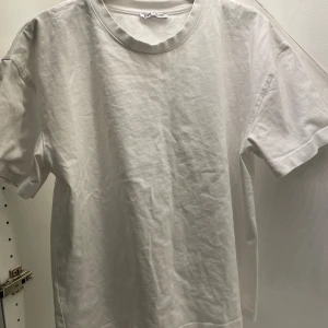 Vit t-shirt från Zara - Säljer en klassisk vit t-shirt från Zara i storlek L. Den har en lite overzised passform