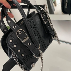 Zara väska  - Cool svart handväska med silverfärgade kedjor, nitar och spännen. Lite mindre defekter på handtagen som ni kan se på bilden men inget mer än de🥰