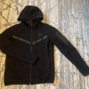 Svart Nike tech fleece storlek S - Svart Nike tech fleece endast använd runt 5 gånger och är i så nytt skick som det går. Vid frågor så är det bara att skriva