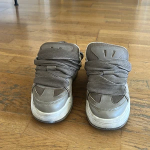 Bruna sneakers från Bershka strl 39 - Säljer ett par chunky bruna sneakers från Bershka i storlek 39. Skorna har breda snören, rund tå och platt sula. Ovandelen är i syntetmaterial med detaljer i mesh och skinnimitation. Insidan är ljus och mjukt vadderad för extra komfort.