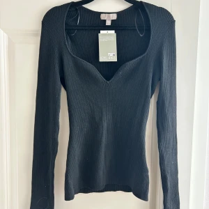 Ribbad topp - Svart ribbad topp med hjärtformad halsringning och med en liten slits i armarna 