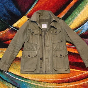 Olivgrön feildjacket ifrån MNG MAN VINTAGE LOOK perfekt skick  - Snygg olivgrön feildjacket från MNG MAN med fyra stora fickor framtill och coola knappar. Jackan har klassisk krage, lång ärm med knappdetalj och är gjord i slitstark bomull. Perfekt för lager-på-lager och chill stil. Perfekt skick 10/10 storlek S men den passar som en M väldigt svår att hitta sällsynt vintage  DM för fler bilder eller frågor 💫🌟🌪️