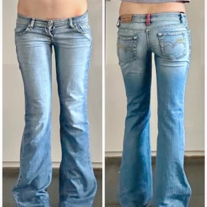Replay bootcut jeans med nitar - Snygga ljusblå bootcut jeans från Replay med coola nitar längs fickorna och gul kontrastsöm. Modellen har låg midja och klassisk femficksdesign. midjemått 36cm, innebenslängd 87cm, grenhöjd 17cm, benöppning 23cm, allt mätt platt.