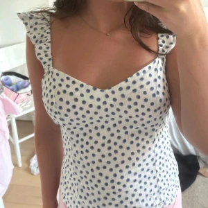 Prickig topp - Superfin prickig vit topp med marinblåa prickar och volanger på ärmarna från H&M💕 