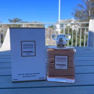 Coco Mademoiselle Eau de Parfum 100ml - Lyxig parfym från Chanel, Coco Mademoiselle Eau de Parfum Intense. Flaskan är rektangulär i transparent glas med ljusrosa doft och elegant, klar kork. Märkets klassiska design med guldiga detaljer och vit etikett. Volymen är 100 ml.
