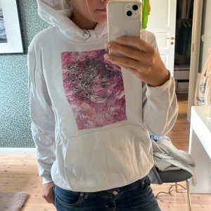 Vit hoodie med konsttryck från The Cool Elephant - Vit hoodie från The Cool Elephant med ett stor tryck fram till. Tröjan har tyvärr en fläck på magen men inget man tänker på. De kan fungera att bleka bort den! 💗💗