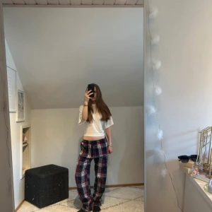 Pyjamasbyxor från Gekås - Mysiga loungebyxor i röd, blå och vit rutig design från Time to Lounge. Byxorna har en loose passform, elastisk midja och snörning för extra komfort. Perfekta för chill dagar hemma eller när du vill vara extra bekväm. Köpta för 120kr