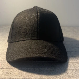 Sixties Svart Keps - Skicka dm för video/prisförslag. Snygg svart keps från sixties.  Sixties  Monogram Cap. Tillverkad i ett slitstarkt syntetmaterial som ger en cool och modern look. Perfekt för dig som vill ha en stilren accessoar med lite edge.