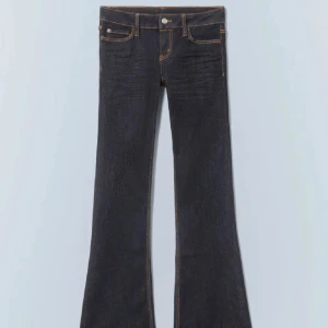 Bootcut jeans från Cheap Monday - Snygga mörkblå bootcut jeans från Cheap Monday med kontrastfärgade sömmar och låg midja i strl 26.30