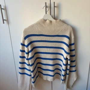 Randig stickad tröja från C.W. - Säljer en ribbstickad tröja från C.W. i storlek S. Tröjan är beige med blåa ränder, har lång ärm och en hög krage. Kommer tyvärr inte till användning 