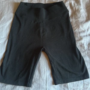 Svarta cykelshorts från C XS - Svarta cykelshorts från C i storlek XS. De har en hög midja och är gjorda i mjukt och stretchigt material som sitter tight mot kroppen. Perfekta för träning eller chill. Klassisk och enkel design utan detaljer eller mönster.