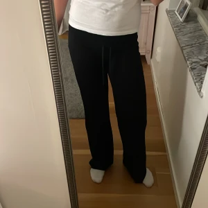 Svarta mjukisbyxor med snörning - Säljer ett par svarta mjukisbyxor med skön loose passform och snörning i midjan. Perfekta för chill dagar eller när du vill vara extra bekväm. Byxorna har raka ben och är gjorda i mjukt material som känns nice mot huden.