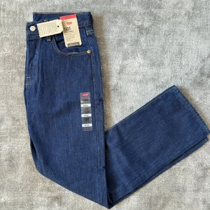Levi's 501 mörkblå jeans W29 L30 - Klassiska Levi's 501 jeans i mörkblå tvätt och snygg passform. Jeansen är tillverkade i 100% bomull och har snygga kontrastsömmar, fem fickor och knappgylf. Dom är aldrig använda så skicket är alltså 10/10, tveka inte på att höra av dig vid frågor och funderingar!!