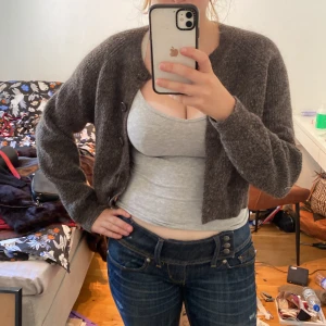 Brun croppad kofta från Lindex - Mysig brun kofta från Lindex i croppad modell med rund hals och långa ärmar. Stickad i mjukt material och har knappar framtill. 