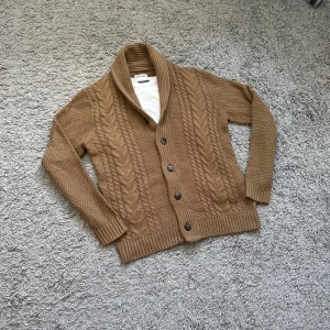 Stickad cardigan  - Säljer nu en väldigt fet stickad cardigan med snyggt ribbat mönster. 9/10 skick - inga defekter. Ljusbrun färg, riktigt snygg!! Pris kan diskuteras! Hör av dig vid frågor 🤩