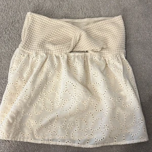 Topp - Supersöt vit topp med bred virkad vid brösten och broderade blommor i tyget. Toppen har en luftig känsla och passar perfekt till varma dagar. Den är gjord i bomull och har en romantisk vibe med sina stora blommönster.