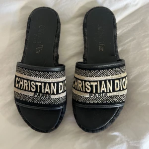 Svarta sandaler - Snygga svarta sandaler. Sandalerna har hög sula med mönstrad kant och öppen tå. Perfekt för dig som vill ha en lyxig och trendig look.