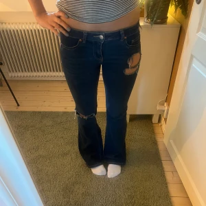 Bootcut jeans med slitningar - Säljer mina mörkblå bootcut jeans från hm. Jeansen har låg midja och egen gjorda hål. Jeansen är endast använda 2 ggr och är därför nästan nyskick! Skriv privat för fler bilder eller frågor❣️❣️