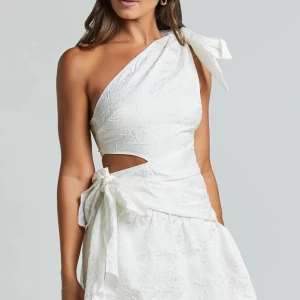 Vit omlottklänning med rosett - Supersöt vit kortklänning från Showpo med ett blommigt mönster i tyget. Köpte som studentklänning men var tyvärr lite för stör för mig och missade att lämna tillbaka den💕💕