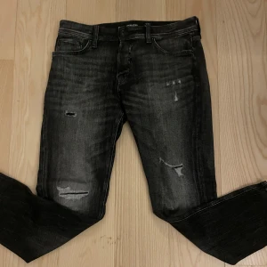 Jack&Jones jeans me slitning - Säljer ett par tvär feta jack&Jones jeans me snygga slitningar och tvätt. Jeansen är väldigt trendiga och eftertraktade. Storlek 30 i midja o 32 i längd. Vid frågor och funderingar är de bara att skriva