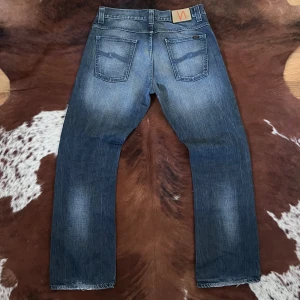 Nudie RegularRalf - Tjena, säljer dessa sjukt feta vintage regular Ralf nudie jeansen, jeansen är i mycket fint skick och har en lagning på knät och på båda hälarna, lagningarna är gjorda hos nudie själva så är knappt något som syns, storlek-W34/L32, hör av dig vid funderingar!🙌