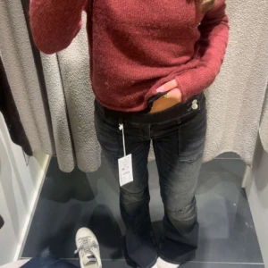 Svarta bootcut jeans från Gina - Snygga svarta jeans från Ginatricot med bootcut passform och låg midja. Jeansen har en tvättad look med lätt slitning på benen och klassiska fem fickor. Perfekta för dig som gillar en avslappnad och trendig stil.