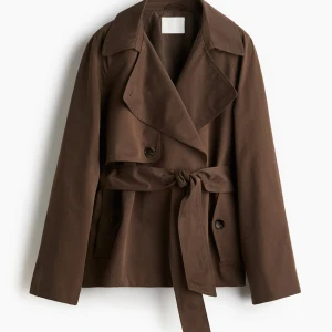 Brun trenchcoat med bälte - Snygg brun trenchcoat med bred krage och knytbälte i midjan. Jackan har dubbla knappar framtill och långa ärmar. Helt slutsåld i alla storlekar hos HM! Är helt ny med alla prislappar kvar💙💙