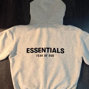 Grå Essentials Fear of God hoodie - Essentials Fear of God hoodie köpt på SecondPlace på triangeln! Extremt bra skick och väl omhändertagen. Nypris: 1899kr. Säljer för runt 1400 men pris går att diskutera. Kvitto finns!