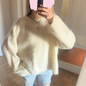 Vit fluffig stickad tröja H&M Edition - Står storlek L men passar mig med S. Så skulle säga onesize. Supermjuk och oversized vit stickad tröja från H&M Edition i mohair- och ullblandning. Tröjan har rund halsringning och långa ärmar, perfekt för lager på lager och en chill vibe. Passar dig som gillar en avslappnad och trendig look.