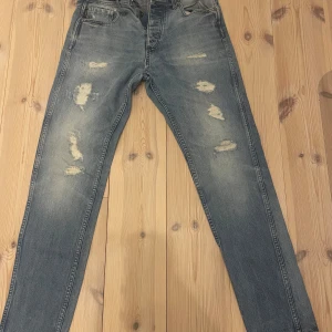 Blå Erik Anti Fit jeans med slitningar - Säljer ett par blå Erik Anti Fit jeans med slitningar framtill. 