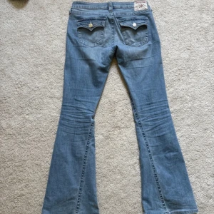 True religion jeans! - True religion joey low rise flare org pris 1299.Dom är köpta av en annan säljare men var tyvärr för stora för mig. Dom hade gått sönder mellan benen men fixade av en skräddare. Det är absolut inget som syns igenom jeansen.🥰💓(sista två bilderna är tagen av säljaren fram ifrån och bakifrån )
