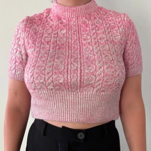 Rosa stickad croppad tröja från Zara - Säljer en rosa stickad croppad tröja från Zara med korta ärmar och glittriga metallic inslag. Endast använd 1 gång. Jag är 163 lång