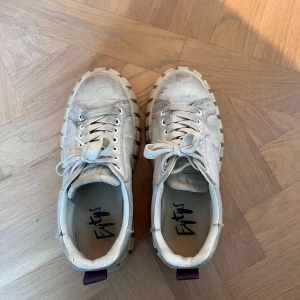 Chunky vita sneakers från Eytys - Säljer ett par chunky vita sneakers från Eytys med grov plattformssula och lila detalj på hälen. 