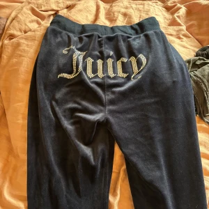 Svarta Juicy Couture mjukisbyxor S - Marinblå mjukisbyxor från Juicy Couture i sammetsliknande material💙. Byxorna har bred resår i midjan med snörning och fickor. På baksidan står det 'Juicy' i glittriga stenar. Klassisk logga broderad framtill vid fickan. Använd fåtal gånger! Nyskick👍🏻🪩