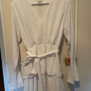 Vit klänning från Madlady - Säljer en vit klänning från Madlady med v-ringning och knytband i midjan. Jättefin men lite har inte kommit till användning. Passar till studenten eller bara en varm sommardag❤️pris går att diskutera