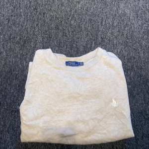 Beige tröja från Polo Ralph Lauren - Säljer en stilren beige tröja från Polo Ralph Lauren. Tröjan har långa ärmar och en liten broderad logotyp på bröstet. Perfekt för en avslappnad och klassisk look. Storlek L men sitter som S/M