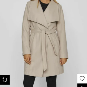 Beige trenchcoat från VILA - Snygg beige trenchcoat från VILA i färgen Natural Melange. Jackan har en klassisk design med ett brett skärp i midjan och stora slag. Perfekt för att ge en stilren look. Orginal pris 899kr jag har gått ner mycket i vikt därför säljer jag den lika bra som ny jag kan posta men köparen står för frakt storken är medium till s den sitter tajt och fint än fast seriösa köpare kan mötas upp i Göteborg 