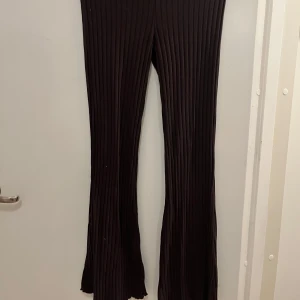 Bruna ribbade byxor - Snygga bruna ribbade byxor med en bootcut-stil. De har en låg midja och materialet är mjukt och stretchigt, vilket ger en bekväm passform.